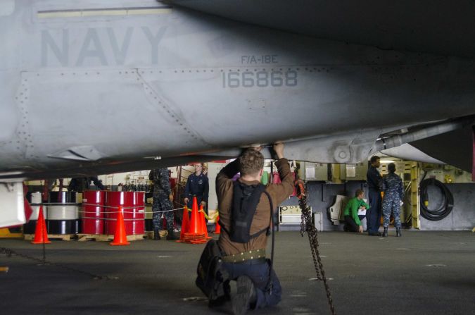 Aircraft carrier crew works on the fuselage of an F/A 18-E Super Hornet. According to the U.S. Navy, there are more than 500 of the aircraft in operation throughout the fleet.