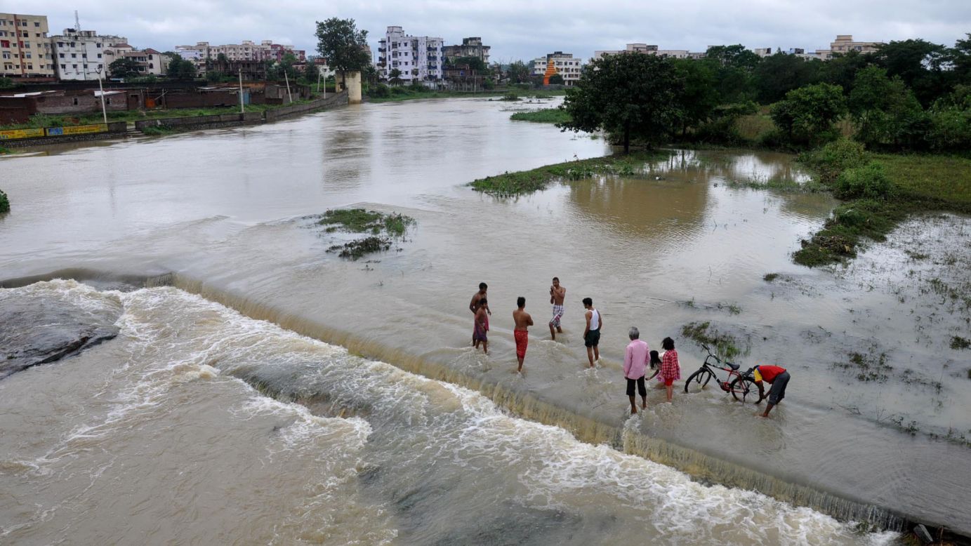 People stand in the overflowing waters of the Swarnrekha River in Ghaghra, India, on October 14.