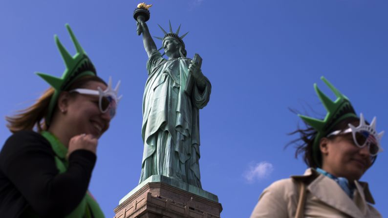 The Statue of Liberty looms over visitors below on Liberty Island in New York Harbor on Sunday, October 13, 2013. The statue was closed to the public by the federal government's partial shutdown that began October 1, 2013, but reopened Sunday after the state of New York agreed to shoulder the costs of running the site during the shutdown.