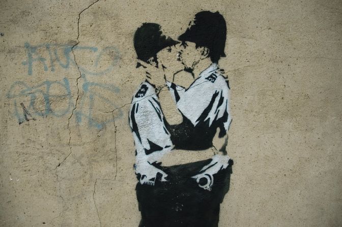 A stenciled image of two policemen kissing is seen in London in 2005. "Kissing Coppers" is one of Banksy's most famous works. Click through the gallery for a look at some of his other notable pieces.