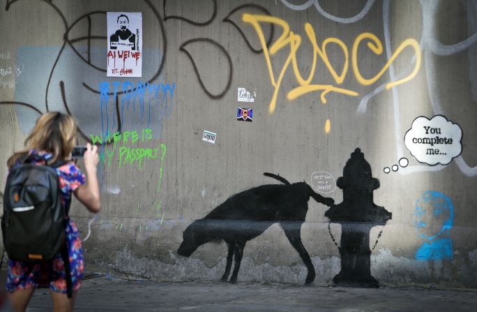 Un mural de Bansky de un perro que orina en una boca de incendio llama la atención el 4 de octubre de 2013. 