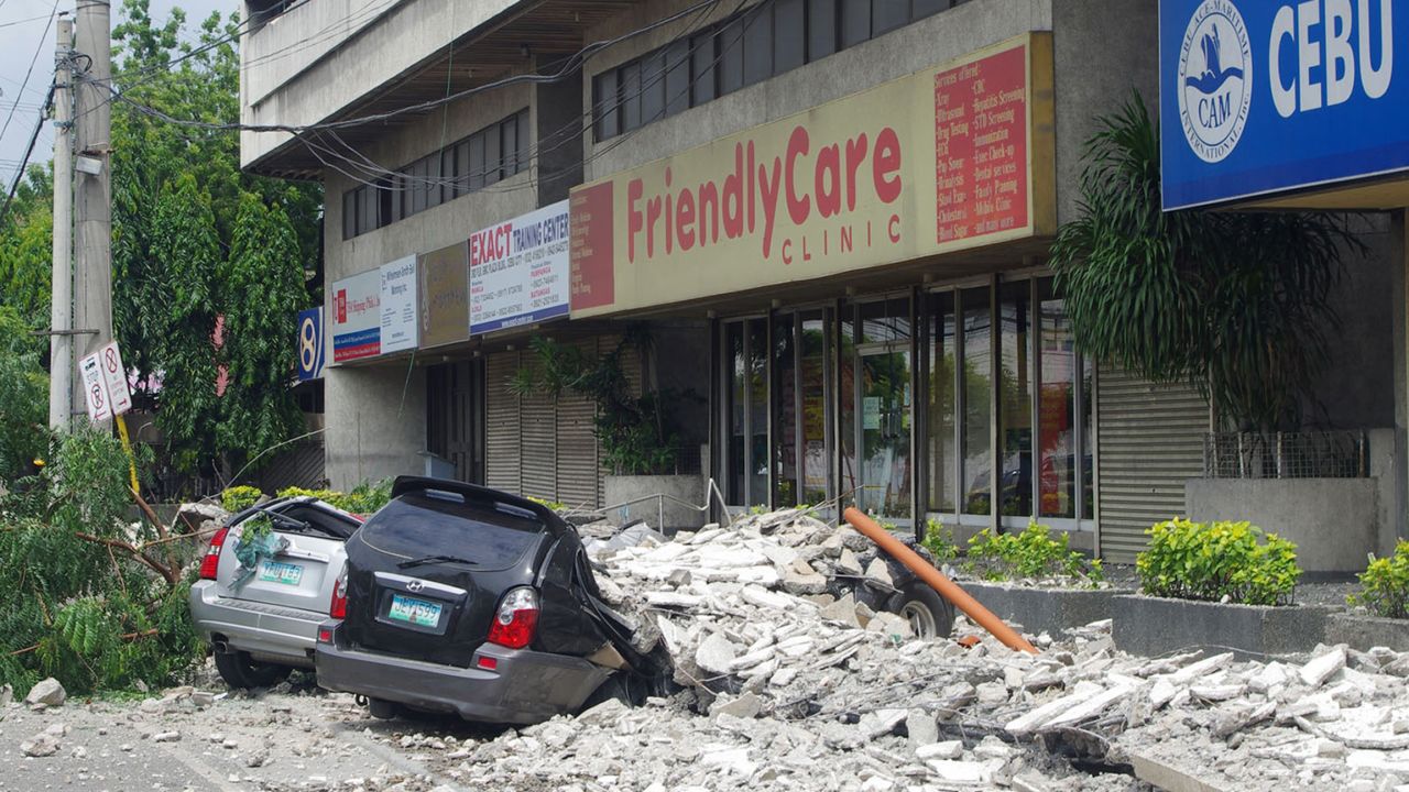 Cars lie under rubble outside the GMC Plaza Building in Cebu on October 15.