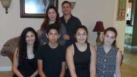 After their father was deported, Cesia Soza, bottom left, and her brother Ronald Jr. have lived with the Sandigo family in Miami.