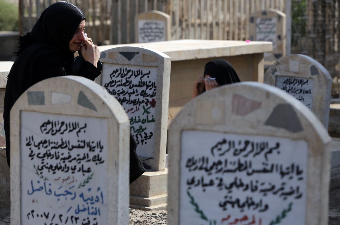 Iraqi women visit the grave of a loved one at a cemetery in Baghdad on October 15. Eid al-Adha began in Iraq with a bomb ripping through a crowd of worshippers as they left a Sunni mosque.