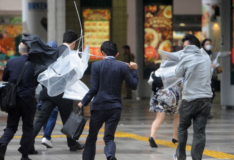 People in Tokyo rush to avoid heavy rainfall and strong winds.