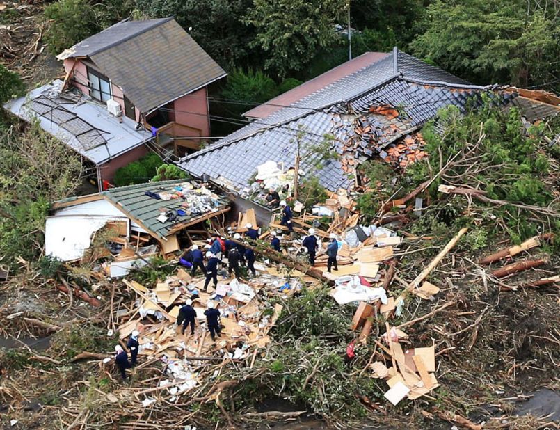 Rescue workers look for survivors as they stand on the rubble of a house buried by mudslides after a powerful typhoon hit Oshima island, about 120 kilometers (75 miles) south of Tokyo on Wednesday.