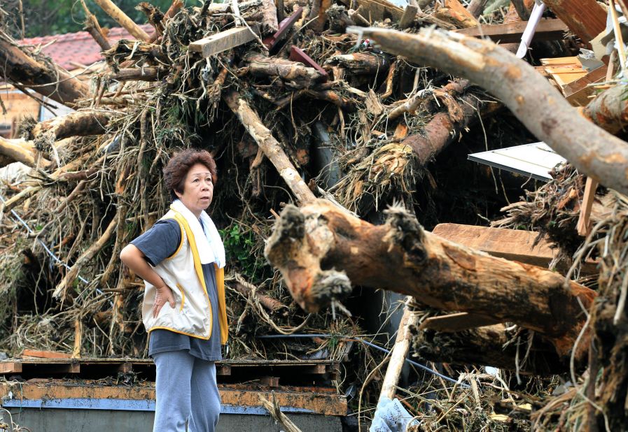 A  woman looks at devastation caused by a landslide.