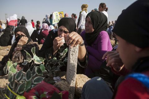 Kurdish women grieve during a visit to a cemetery in Derik, Syria, on Tuesday, October 15.