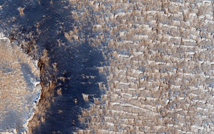 Los vientos incesantes de Marte crean dunas de arena por toda la superficie. Sin embargo, debajo de estas dunas en Syra Planum se encuentran depósitos brillantes con frentes empinados y orillas afiladas y erosionadas. Estos depósitos más bajos son evidencia de que en el pasado de Marte, los vientos eran mucho más feroces.