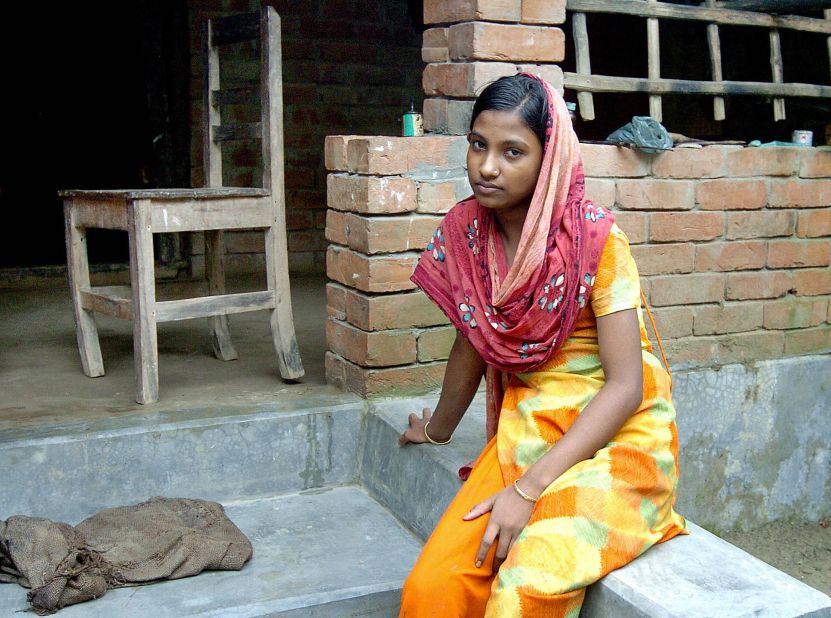 Moyna sits outside her home in the town of Kalora, Bangladesh. As a 14-year-old, she found herself working in an Indian brothel after being tricked into believing she had taken a job in a steel factory.