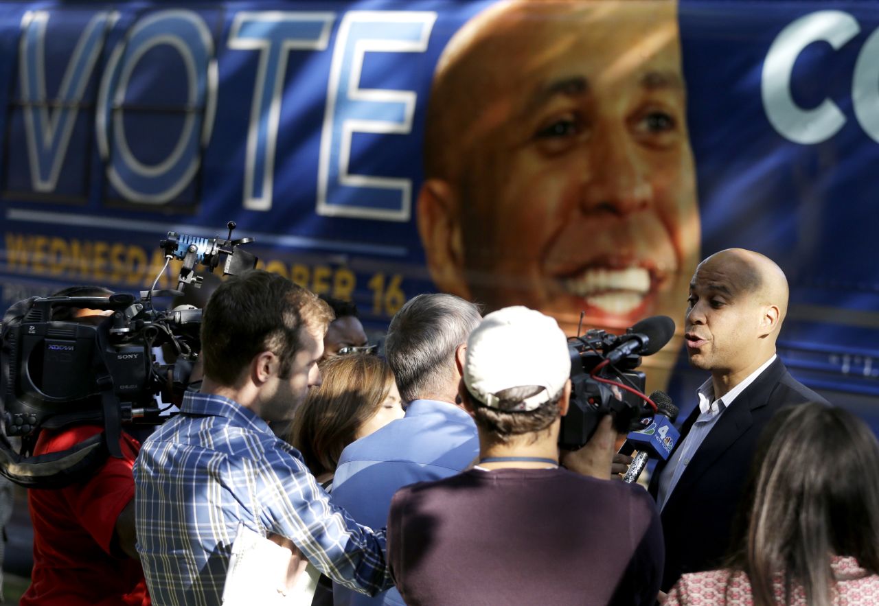 Booker talks to reporters near his tour bus while visiting supporters at a Newark senior center on October 15.