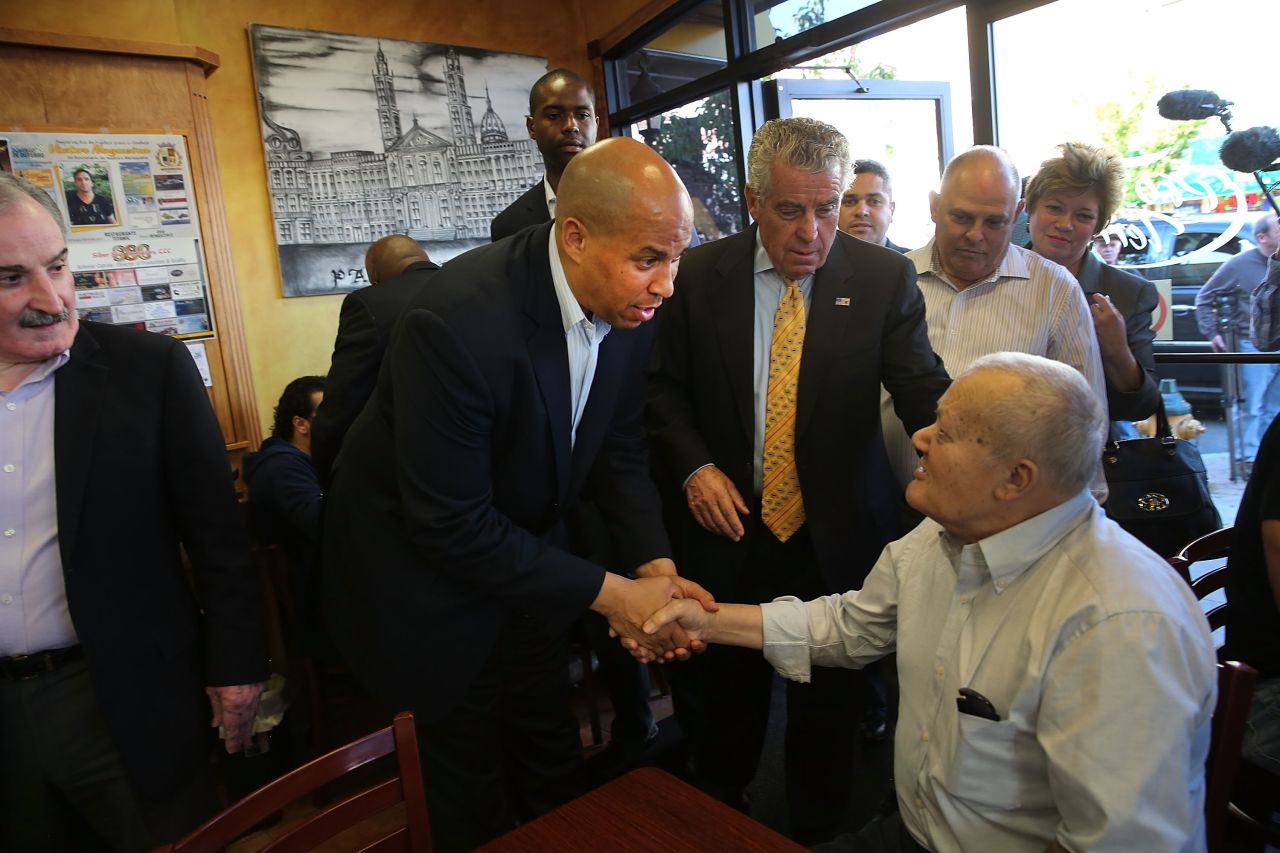 Booker greets a man while campaigning in downtown Newark on October 15.