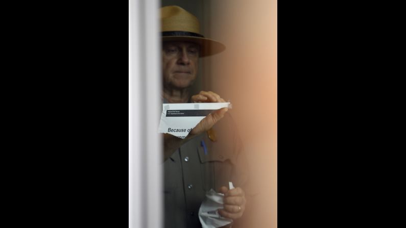 A National Park Service ranger takes down a notice about the government shutdown at the Liberty Bell Pavilion in Philadelphia on October 17.