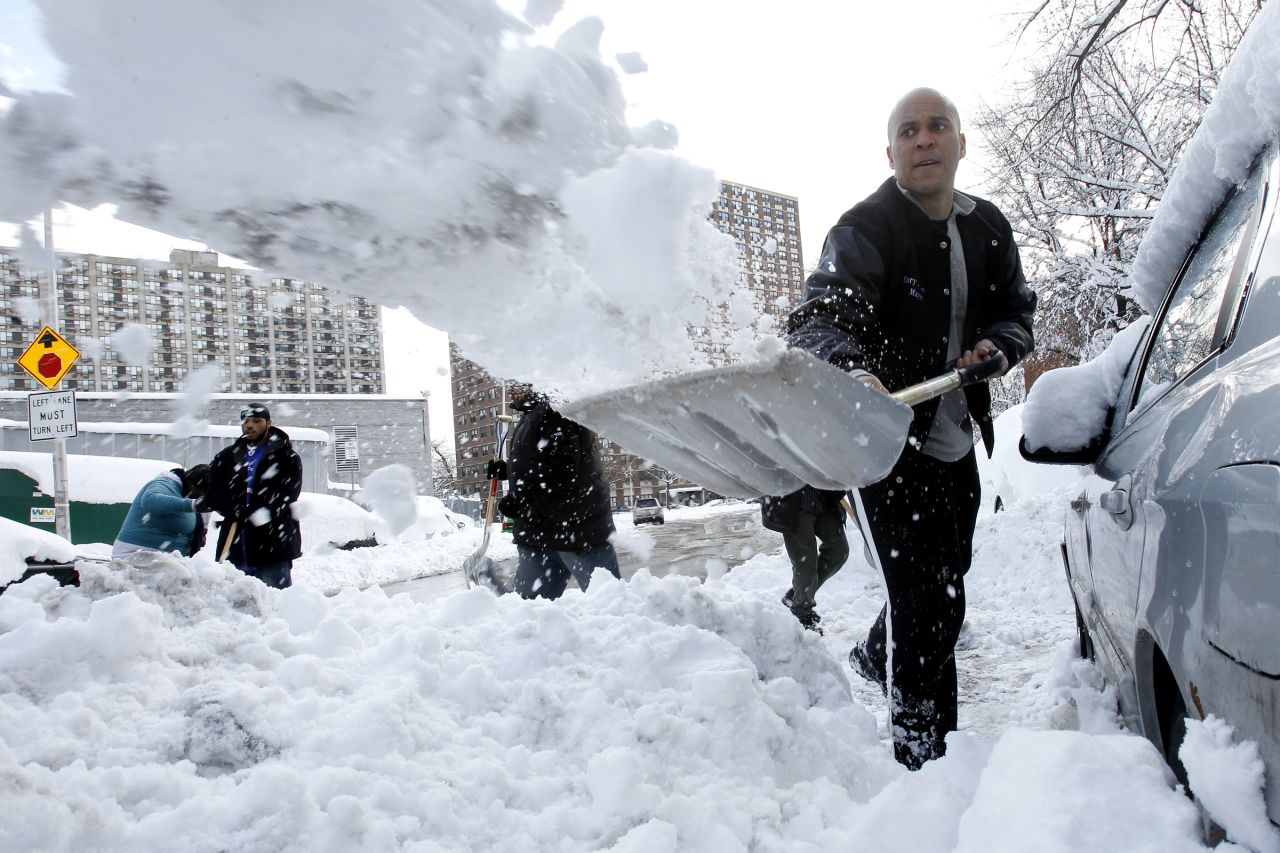 Booker digs out Newark resident Jasmine Ingram's vehicle in January 2011. "It was very nice. I didn't expect it, so it was shocking," said Ingram, who was one of four people to have their vehicles dug out by the mayor and a group of residents.