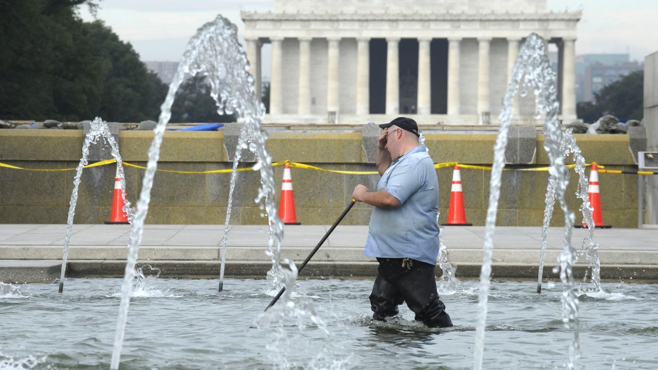 A worker cleans the fountain at the National World War II Memorial in Washington on October 17. The Lincoln Memorial is in the background.
