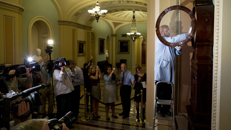 Museum specialist Richard Doerner winds the historic timepiece known as the Ohio Clock outside the Senate chamber on October 17. The clock stopped during the 16-day shutdown when federal workers were furloughed.