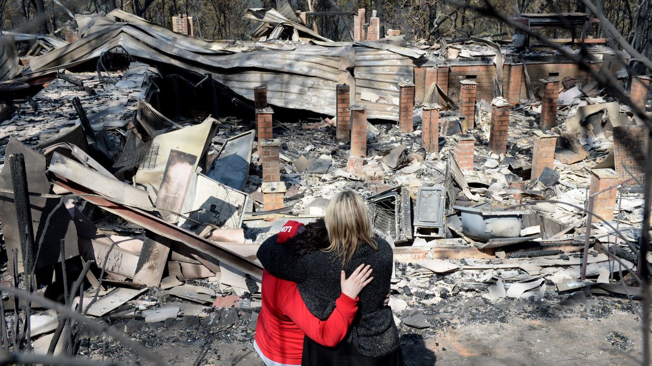 Victims look over the remains of their home on Friday, October 18, after a devastating bush fire passed through Winmalee in the Blue Mountains.