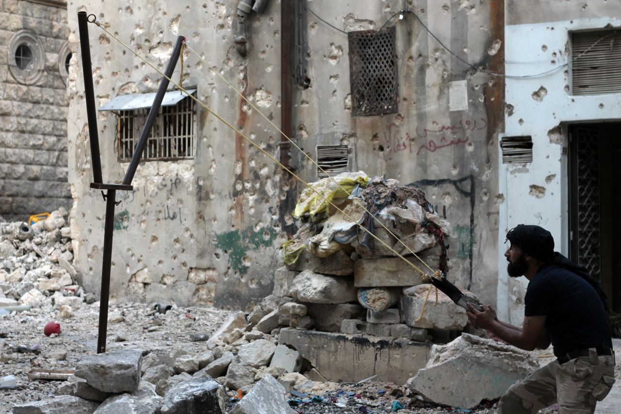 A Syrian opposition fighter aims a catapult toward regime forces in Aleppo, Syria, on Thursday, October 17.