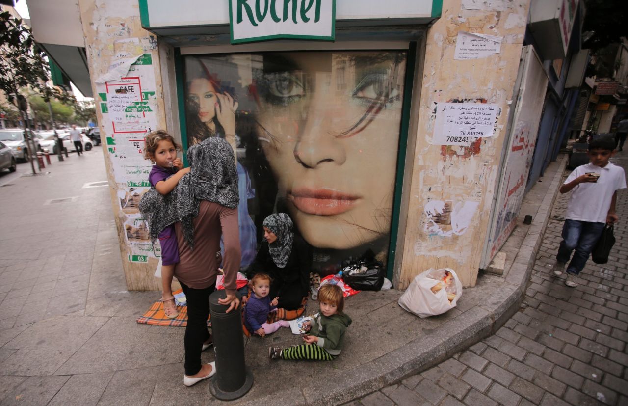 A Syrian refugee begs with her children on a street in Beirut, Lebanon, on Friday, October 18.