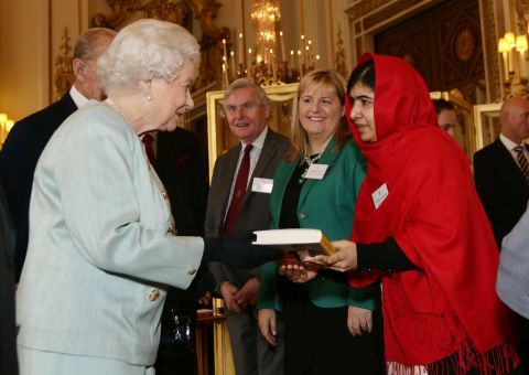 Malala gives a copy of her book to Britain's Queen Elizabeth II during a reception at Buckingham Palace in October 2013.