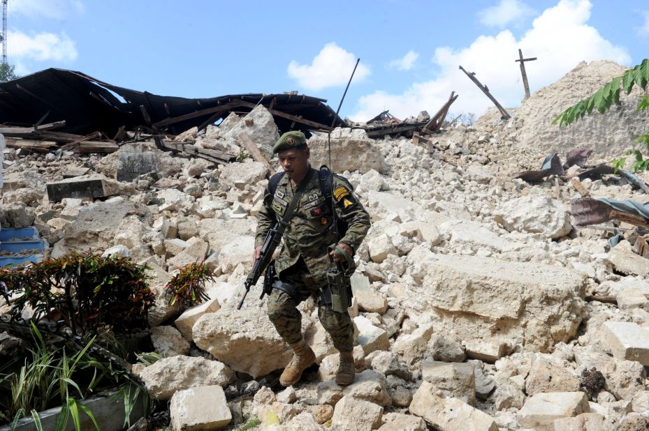A Philippine soldier walks through the ruins of the historic Holy Cross Parish Church in Maribojoc on October 18.