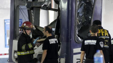 Firefighters inspect a commuter train that failed to stop and crashed at the end of the line at a railway terminal in Buenos Aires.