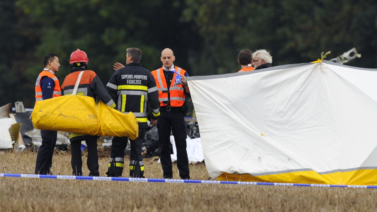 Belgian firefighters investigate at a site where a plane carrying 10 parachutists crashed shortly after takeoff, October 19, 2013.
