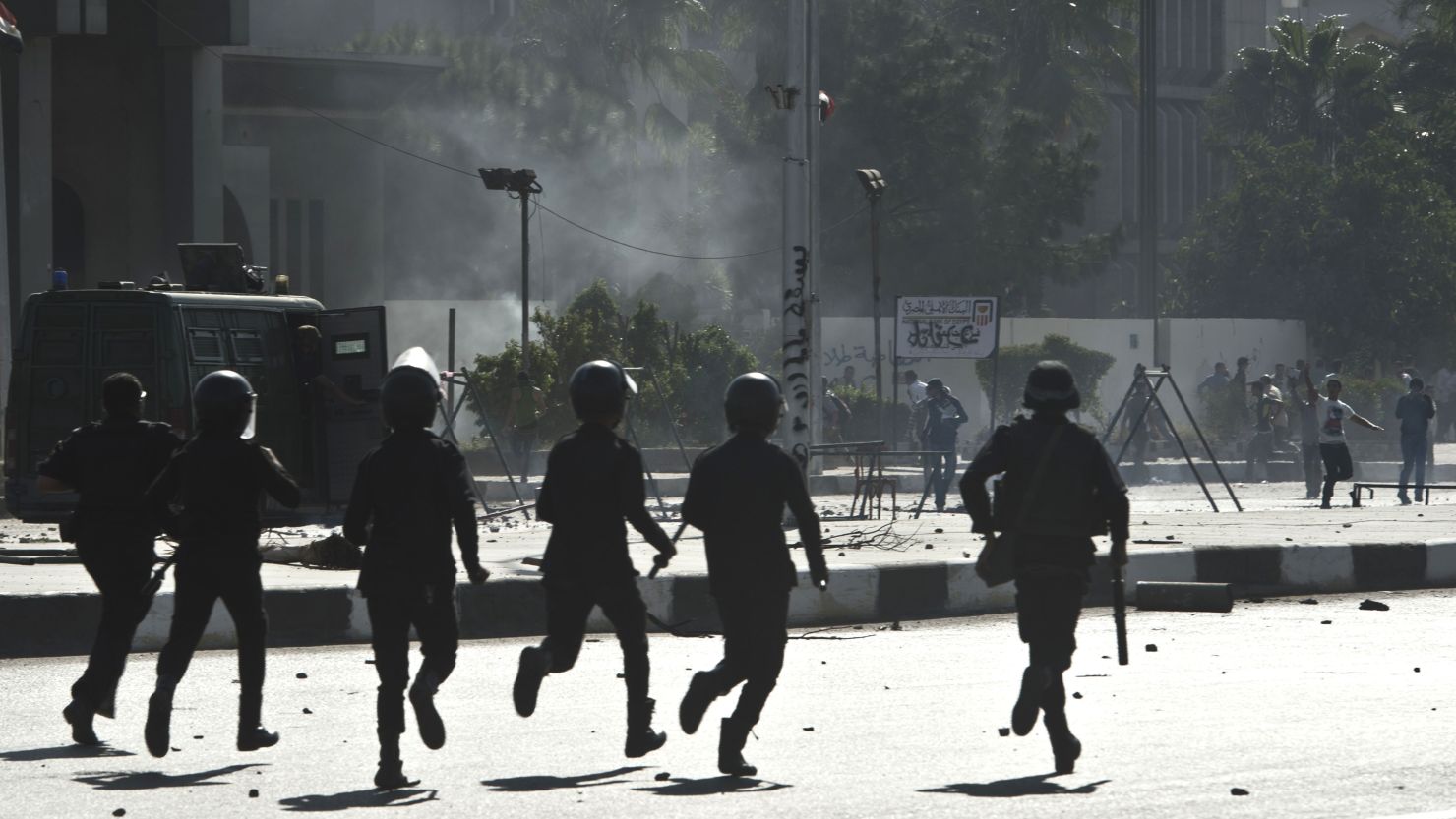 Riot police run toward students outside the al-Azhar University in Cairo on Sunday during a pro-Morsy demonstration.