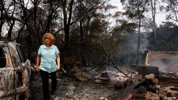 Leanne Brown inspects the remains of her home following severe bush fires on October 18, 2013 in Winmalee, Australia.
