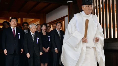 Japanese lawmakers follow a Shinto priest  during a visit to the Yasukuni shrine in Tokyo on October 18, 2013.