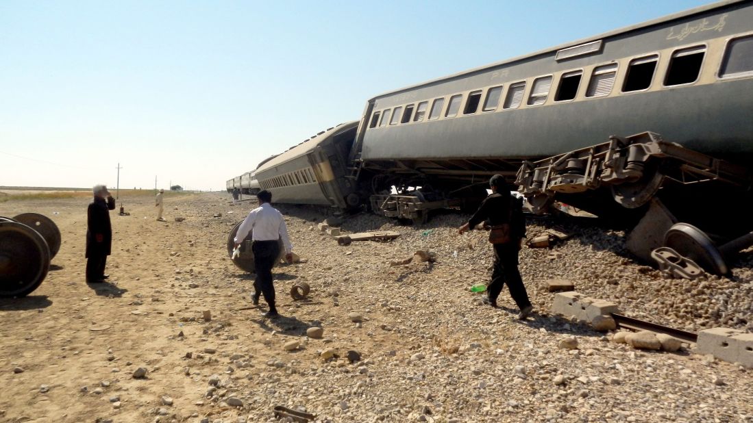 People survey the wreckage of a Jaffar Express train hit in three blasts near Naseerabad district in Pakistan's Balochistan province on Monday, October 21. The train was carrying hundreds of passengers traveling after the Eid al-Adha holidays. At least seven passengers were killed, authorities said.