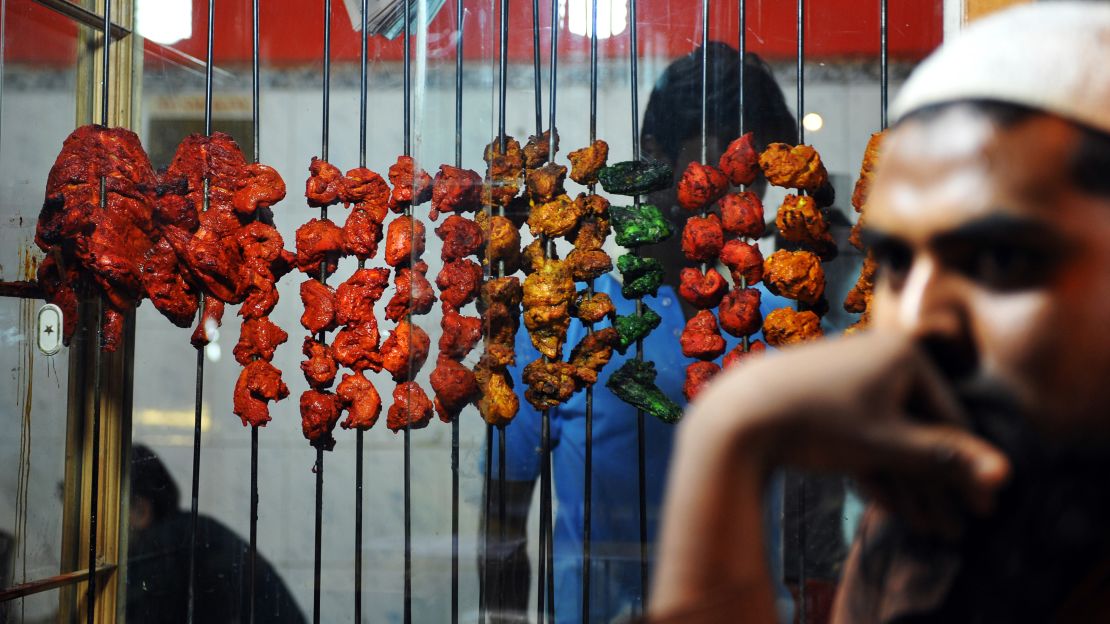 A man selling kebabs waits for customers by the side of a busy road in Bangalore, in the southern Karnataka state.