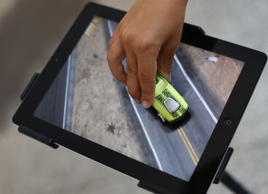 iPads and other tablets have become popular gaming platforms, especially among children. Here a child in London plays with an app from Mattel that allows kids to use Hot Wheels cars and other toys to interact with an iPad.