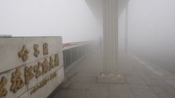 A woman stands on a bridge under heavy smog in Harbin, northeast China's Heilongjiang province, on October 21, 2013. Choking clouds of pollution blanketed Harbin, which is famed for its annual ice festival, reports said, cutting visibility to 10 metres (33 feet) and underscoring the nation's environmental challenges. CHINA OUT AFP PHOTO (Photo credit should read STR/AFP/Getty Images)
