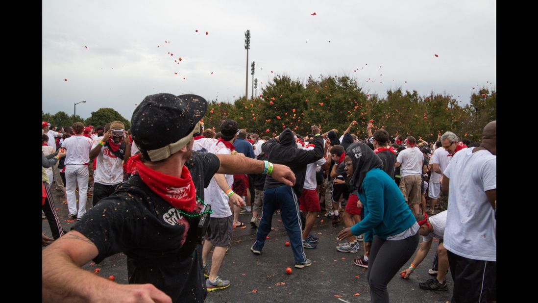 Hundreds of people throw and dodge rotten tomatoes during the Tomato Royale, part of the Great Bull Run event on October 19.