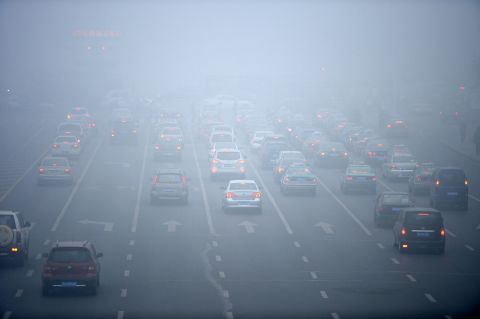 Drivers try to make their way through the smog in downtown Harbin on October 22.