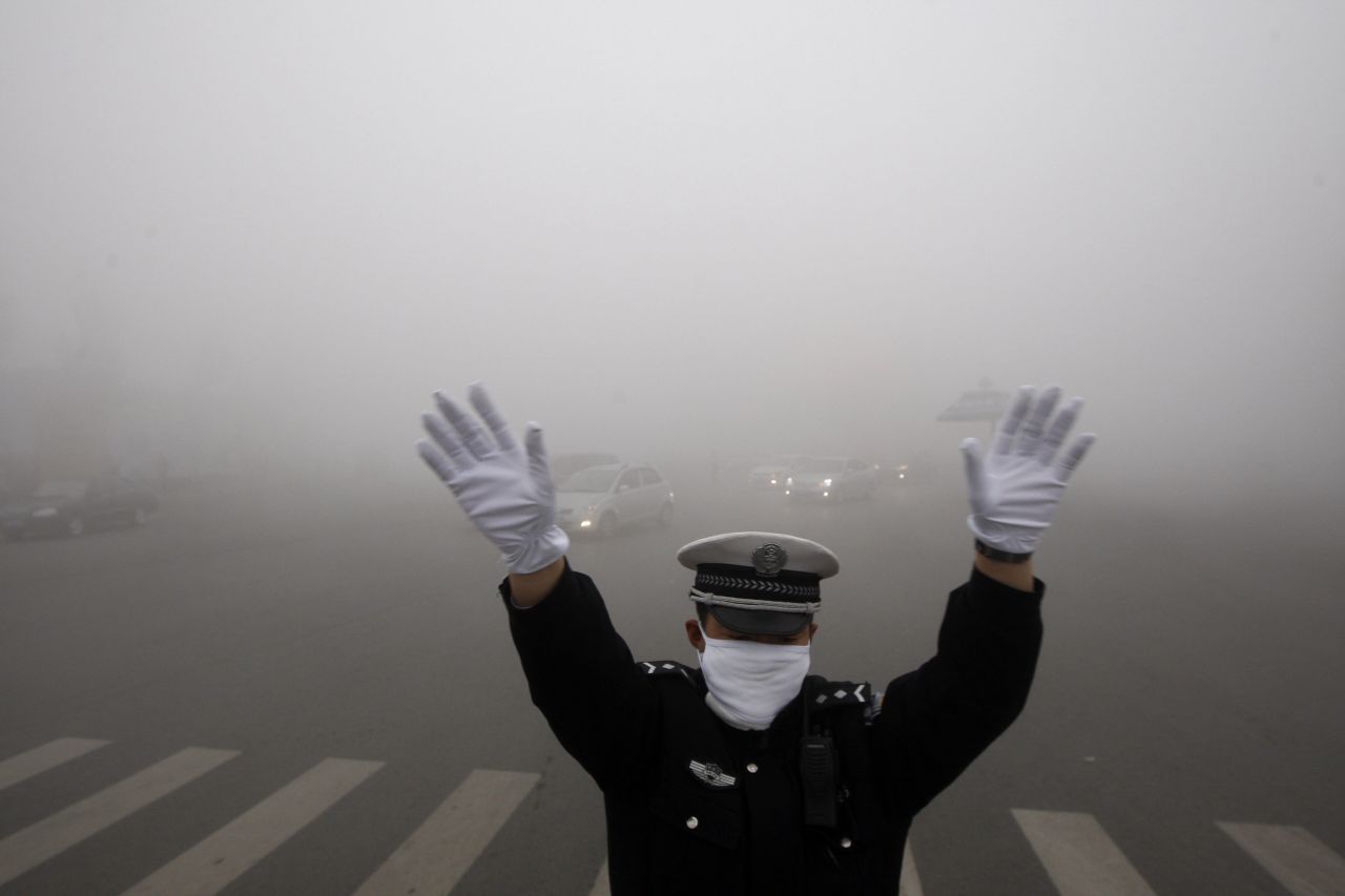 Un policía dirige el tráfico de Harbin. En zonas centrales de la ciudad, la visibilidad fue menor a 20 metros. 