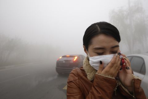 A woman walks in the Harbin smog October 21. "We can smell the smoke in the air," one man told CNN.