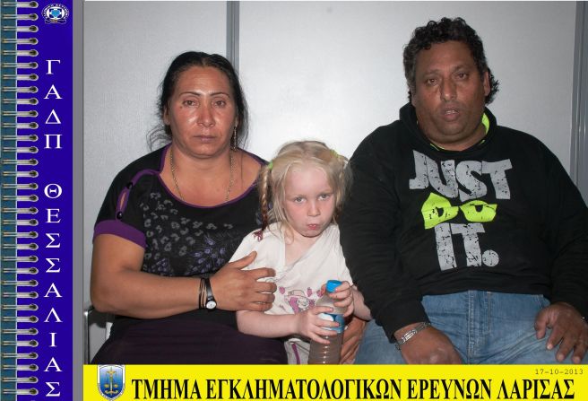 In this handout photo provided by police, suspects Eleftheria Dimopoulou, 40, and Christos Salis, 39, sit with the girl. A lawyer for the couple told the Reuters news agency that the couple adopted the girl with the permission of her biological mother.