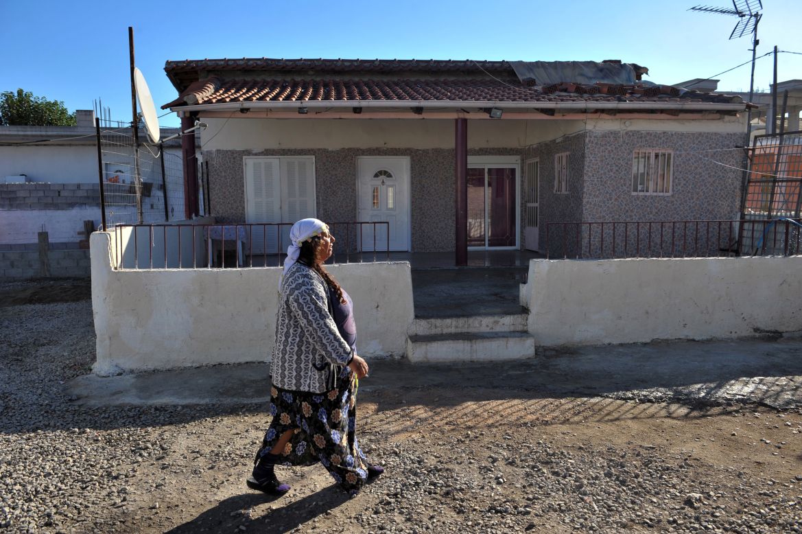 A Roma woman walks next to the house where the family lived in Farsala. A spokesman for Smile of the Child, the charity that took Maria in, said the girl was found in "bad living conditions, poor hygiene."