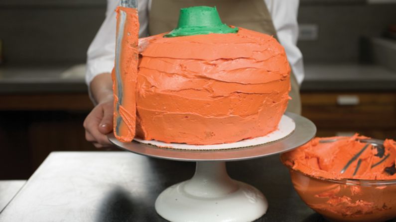 Using a cake spatula, cover the entire cake with orange frosting. <a href="http://eatocracy.cnn.com/2013/10/24/pumpkin-cake/">See the full recipe.</a>