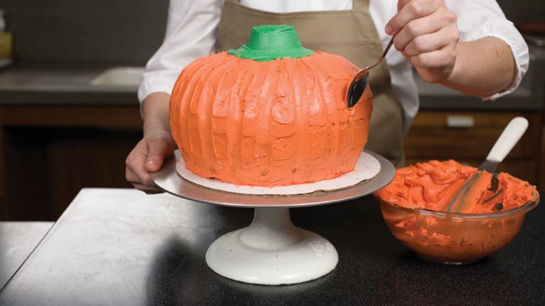 Run the back of a small spoon up the sides of the orange frosting every few inches to create pumpkin "creases." <a href="http://eatocracy.cnn.com/2013/10/24/pumpkin-cake/">See the full recipe.</a>