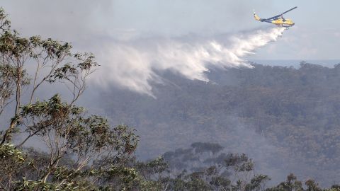 A helicopter drops water on fires burning in Faulconbridge on Thursday, October 24.