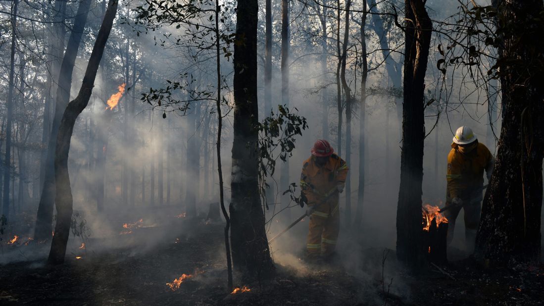 New South Wales Rural Fire Service crews mop up an area after stopping a fire in Bilpin in the Blue Mountains of Australia on October 23.