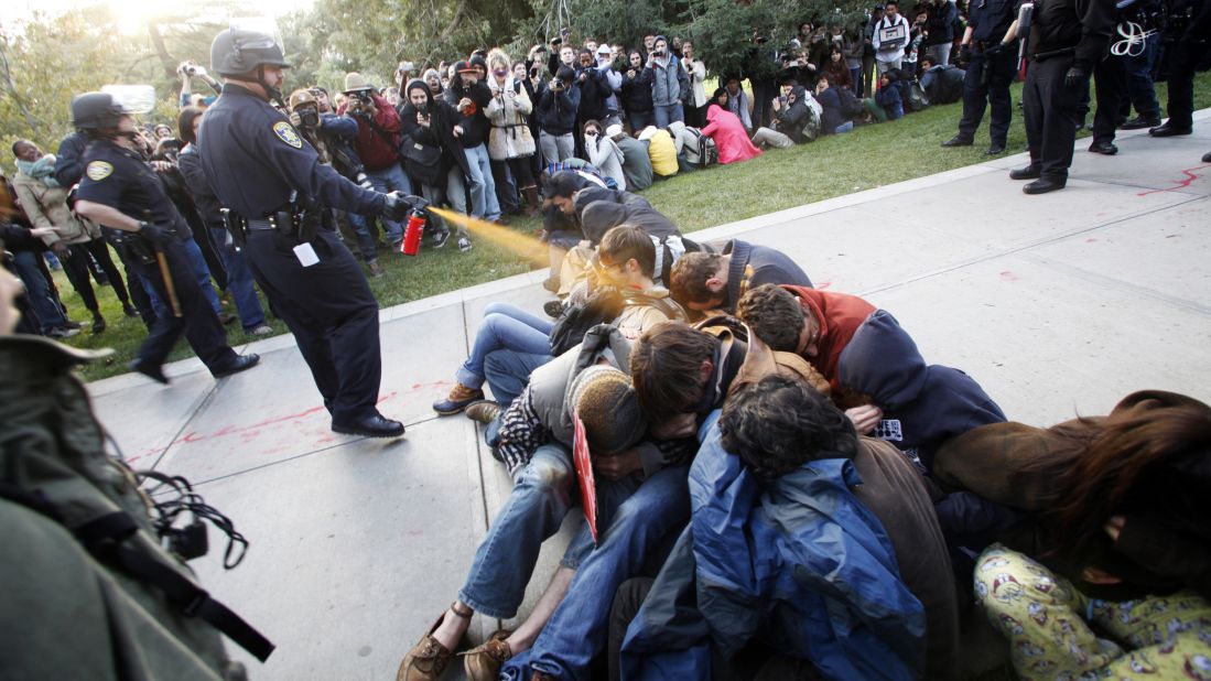 Police Lt. John Pike at the University of California, Davis, uses pepper spray to break up Occupy UC Davis protesters on the school's quad on November 18, 2011. This image sparked controversy amid the Occupy protests and fueled the flames for protesters. A judge ruled that the university must pay Pike $38,000 in workers' compensation for the depression and anxiety he suffered as a result of the backlash from the incident. 