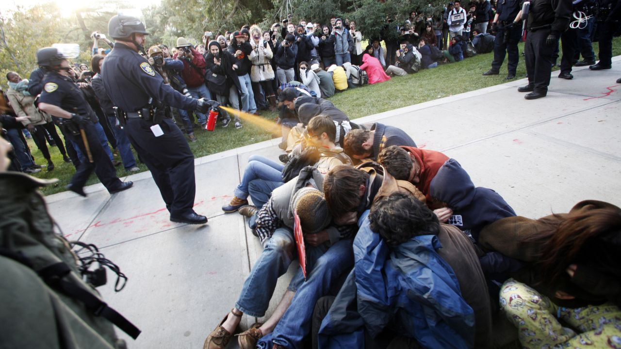 Police Lt. John Pike at the University of California, Davis, uses pepper spray to break up Occupy UC Davis protesters on the school's quad on November 18, 2011. This image sparked controversy amid the Occupy protests and fueled the flames for protesters. A judge ruled that the university must pay Pike $38,000 in workers' compensation for the depression and anxiety he suffered as a result of the backlash from the incident.