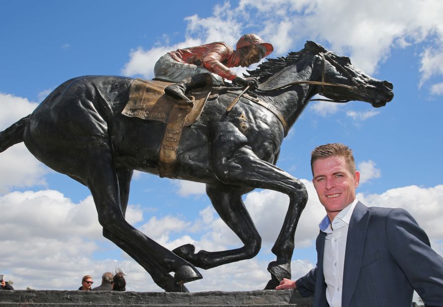Nolen stands alongside the sculpture of the horse which he rode to 22 of her 25 victories.