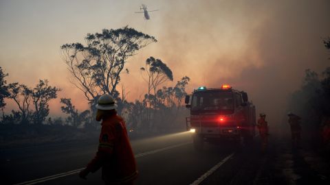 New South Wales Rural Fire Service crew members fight a fire near Mount Wilson in the Blue Mountains of Australia on Thursday, October 24. Wildfires threatened the western suburbs of Sydney on Wednesday as high winds and temperatures created at least a dozen new fires that were blazing across a 1,000-mile stretch of New South Wales.