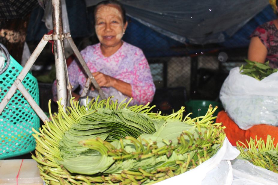 A woman sells betel leaves at a market in central Yangon. The climbing plant is grown thro
