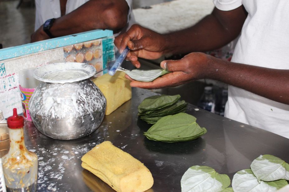 Kyaw Thet works quickly at his stall in central Yangon. He first coats the betel leaves in slaked lime before lining them up in rows on the counter to add the extra ingredients.